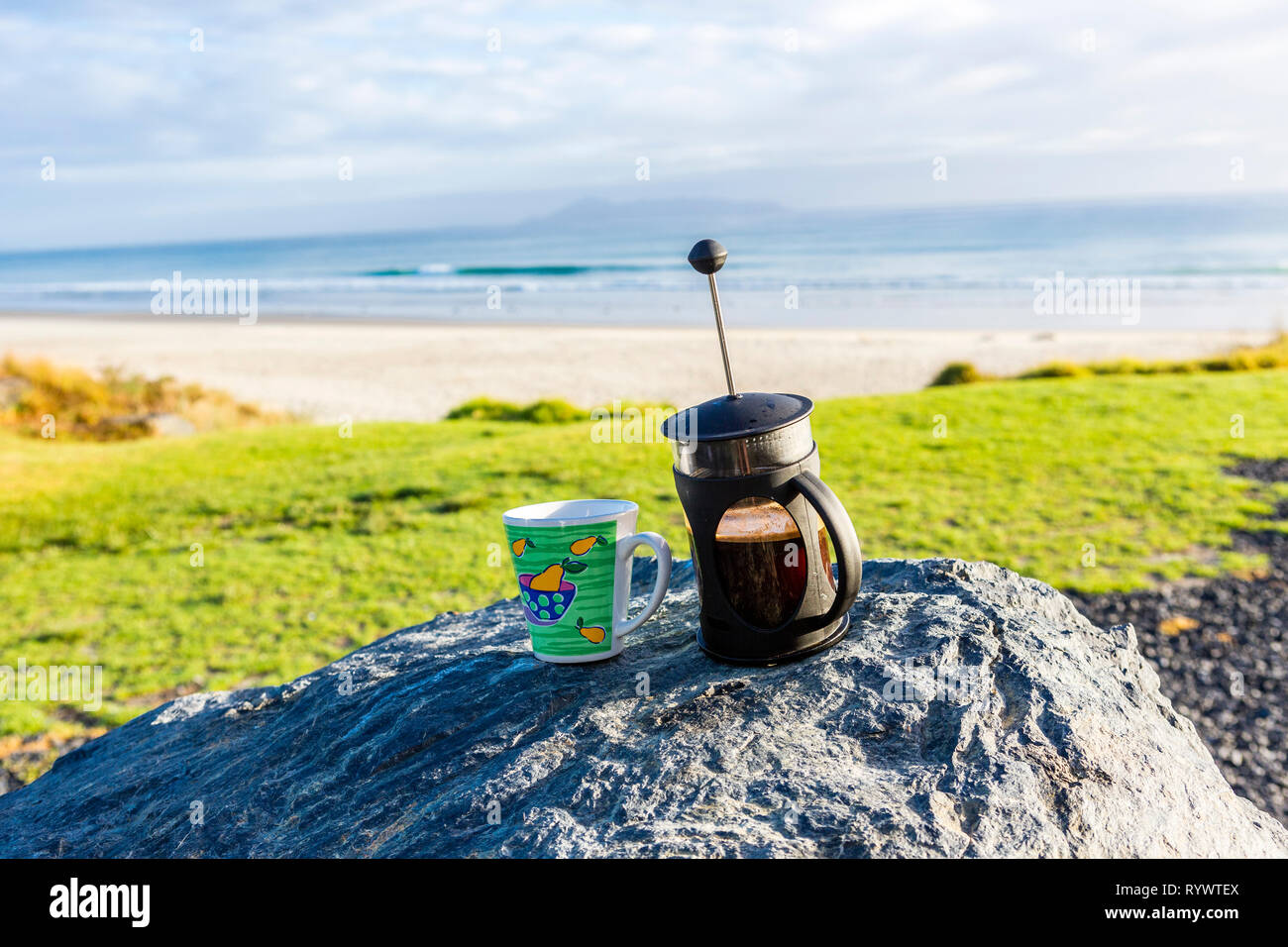 Coffee cup and french Press on rocks with wonderful Bayview, Northland New Zealand Stock Photo