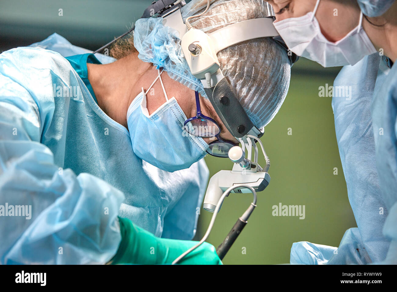 Team of surgeons makes an invasive operation. Portrait of surgeons close-up. Work with a coagulating instrument, vascular coagulation Stock Photo