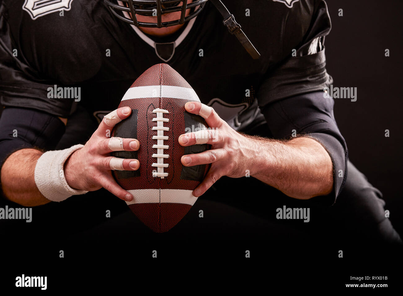 American football sportsman player in helmet on black background