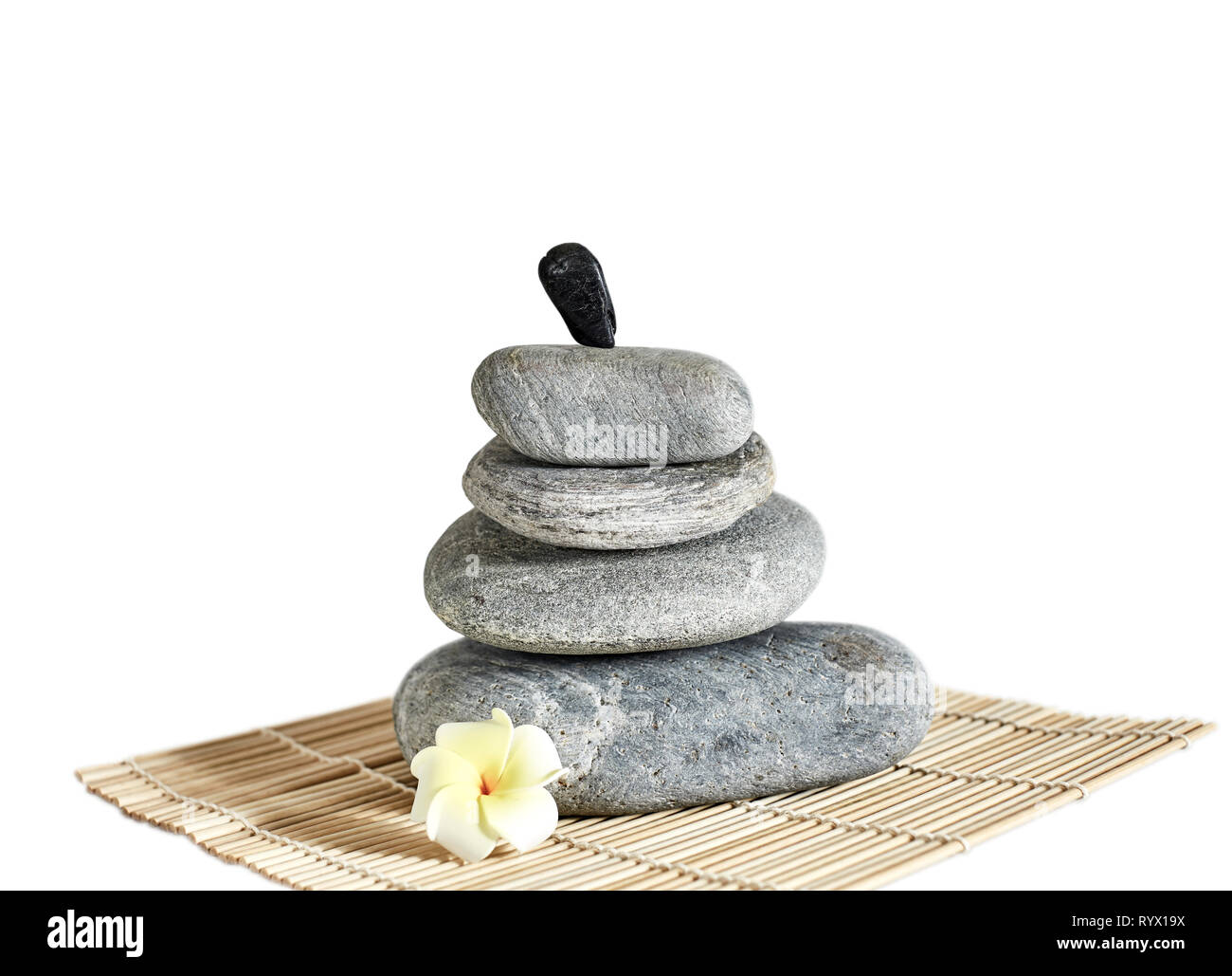 River rocks balanced on one another on a bamboo mat with a ...