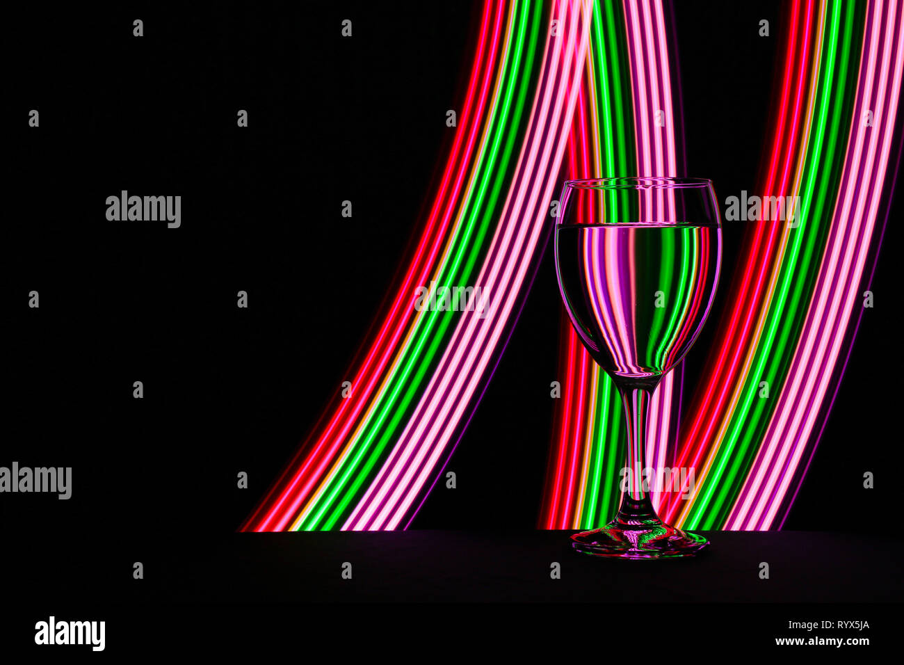 Wine glass / glasses isolated on a black background with colorful