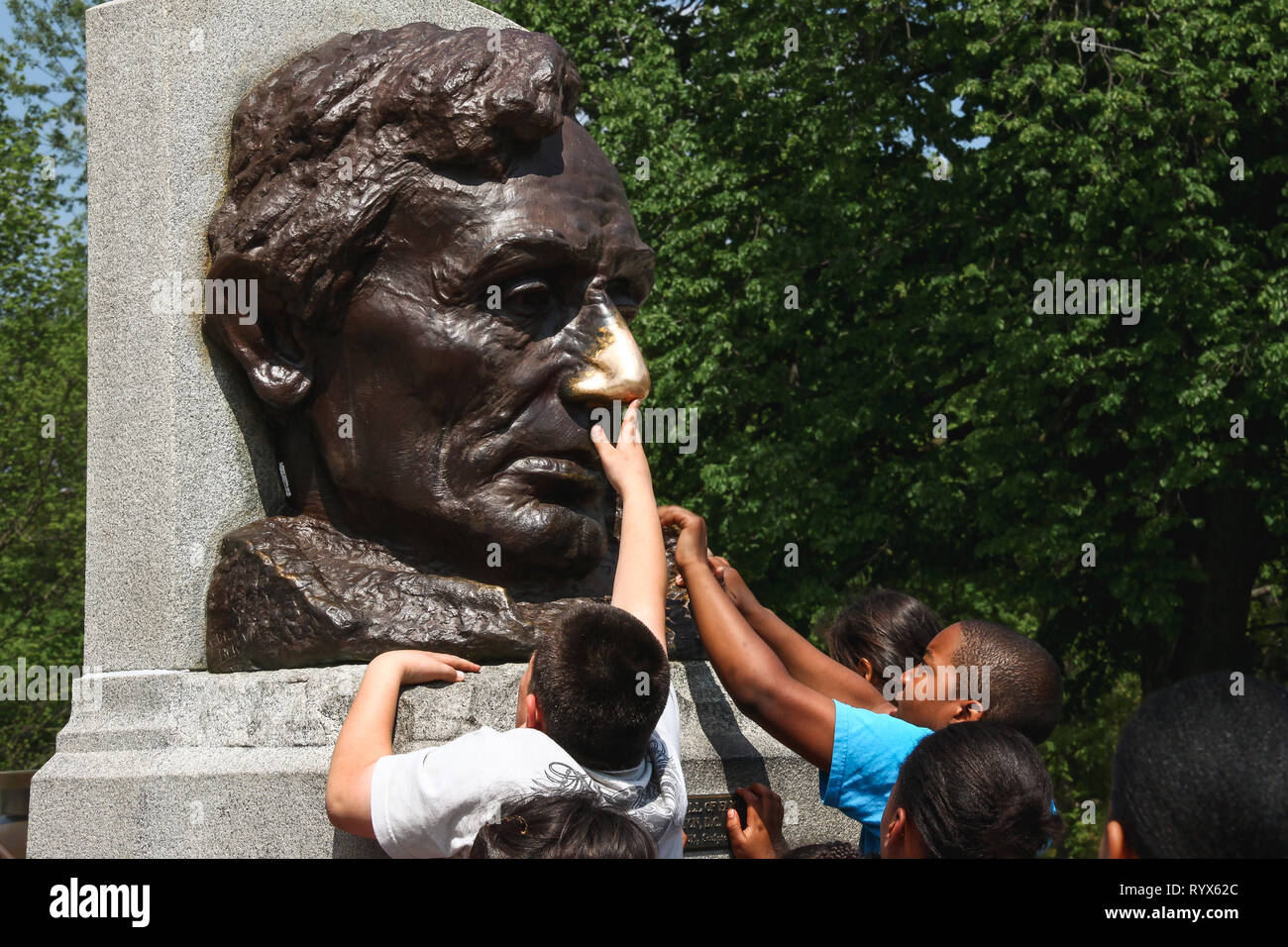 Children touching the polished nose of an Abraham Lincoln sculpture in Springfield, Illinois Stock Photo
