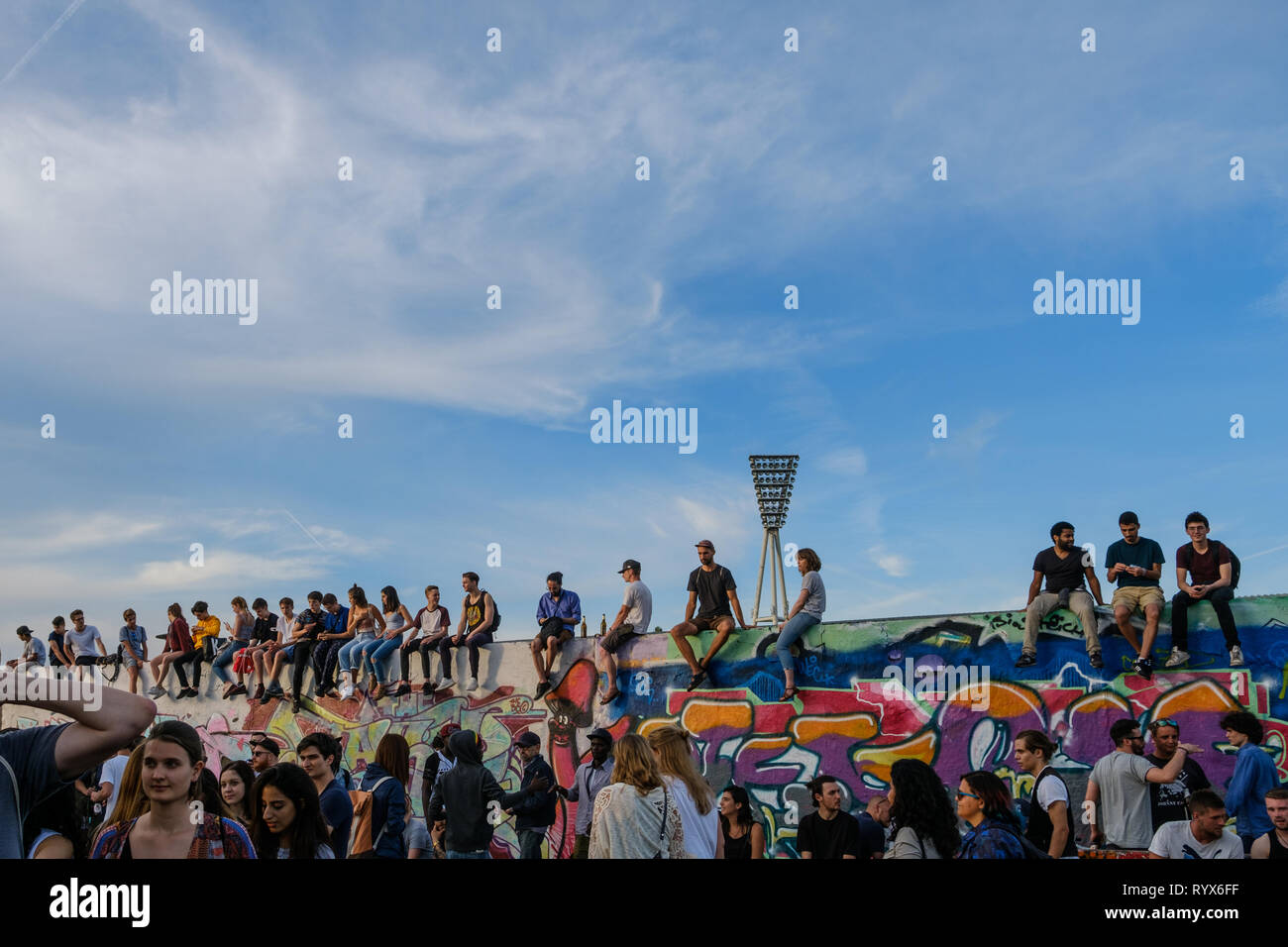 Berlin, Germany, may 2017: Many young people sitting on wall in crowded park (Mauerpark) at 'fete de la musique' in Berlin, Germany. Stock Photo