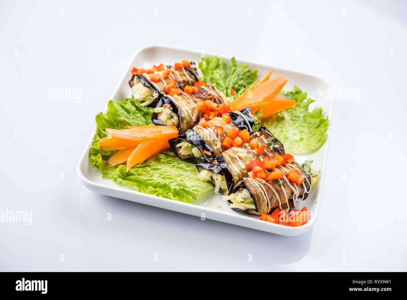 eggplant rolls with nuts on a white plate Stock Photo