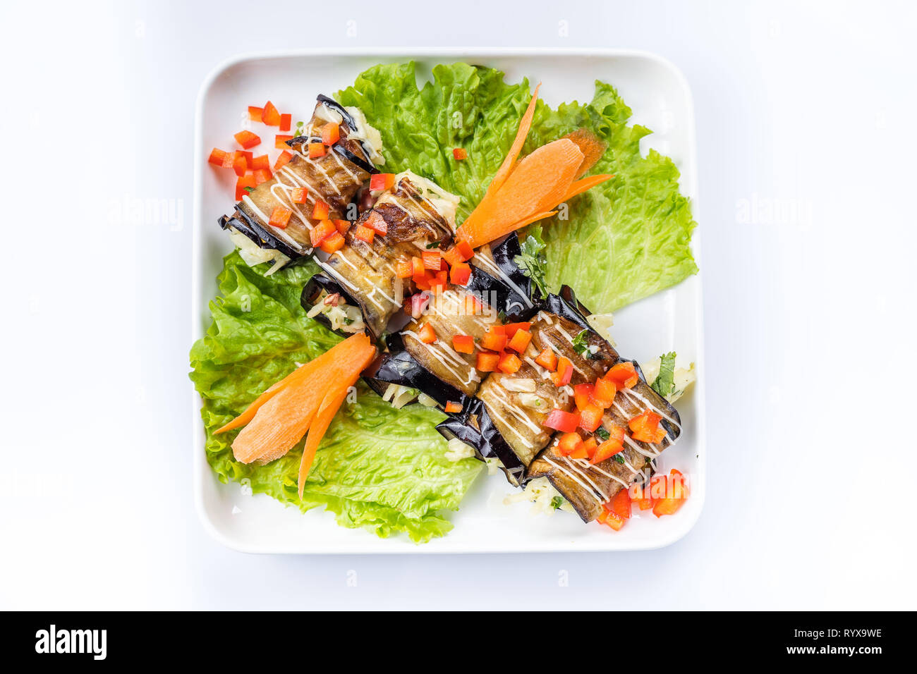eggplant rolls with nuts on a white plate Stock Photo