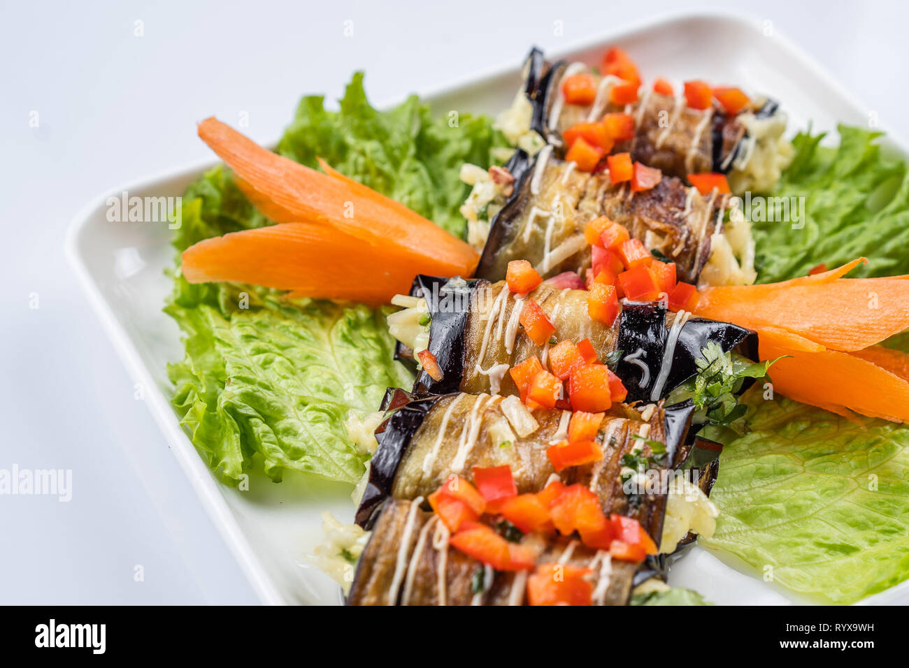 eggplant rolls with nuts on a white plate Stock Photo