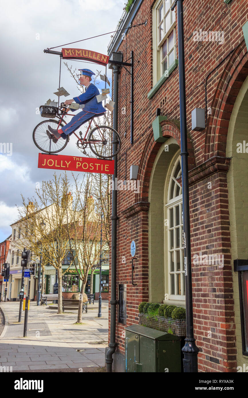 jolly postie hanging signpost, old post office site,royston village , town centre, high street, hertfordshire, england, uk gb Stock Photo