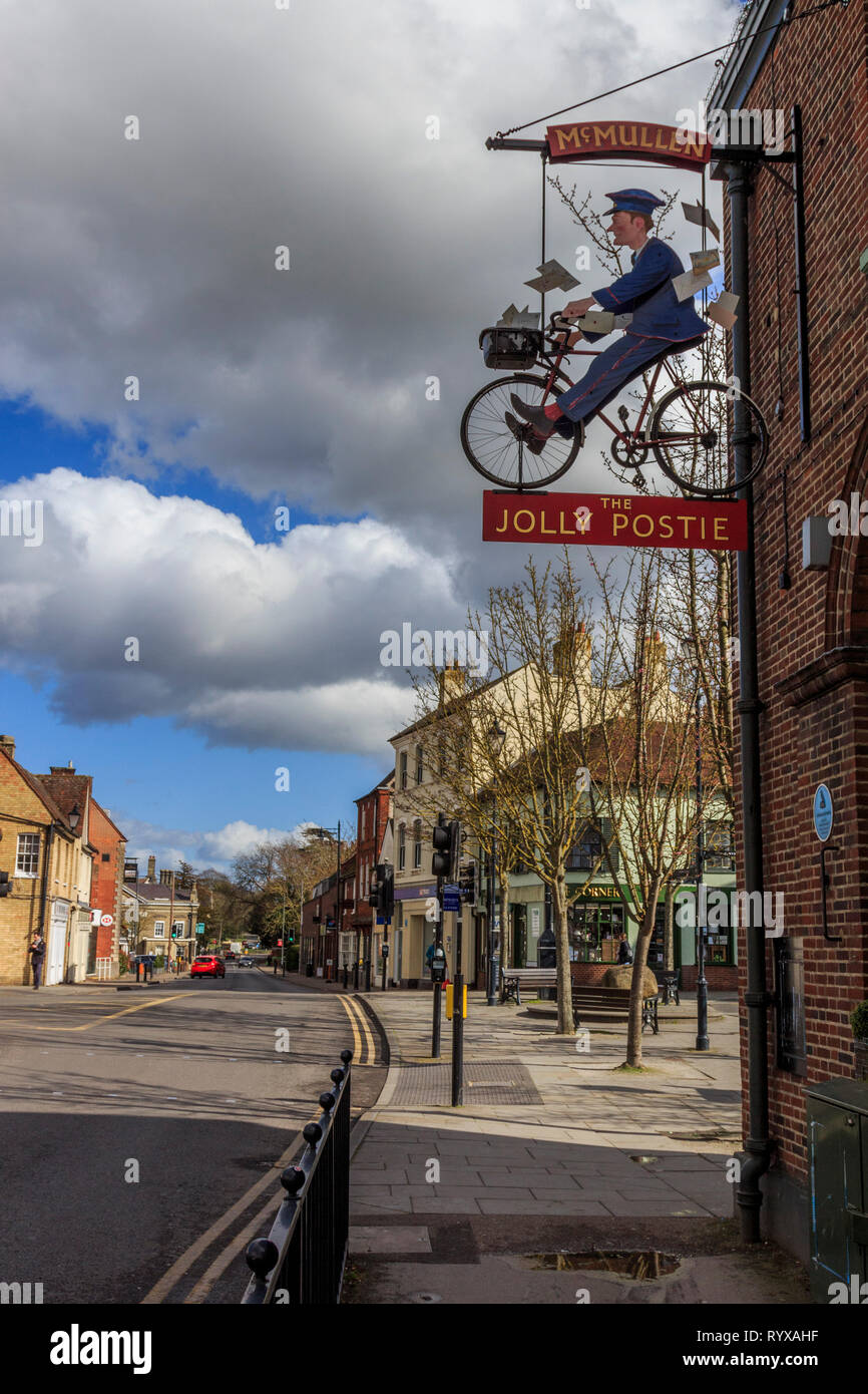 jolly postie hanging signpost, old post office site,royston village , town centre, high street, hertfordshire, england, uk gb Stock Photo