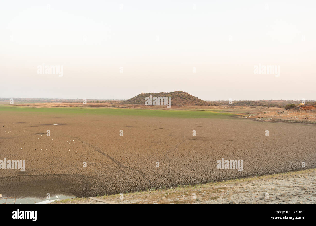 A dried up empty reservoir or dam during a summer heatwave, low rainfall and drought in north karnataka,India Stock Photo