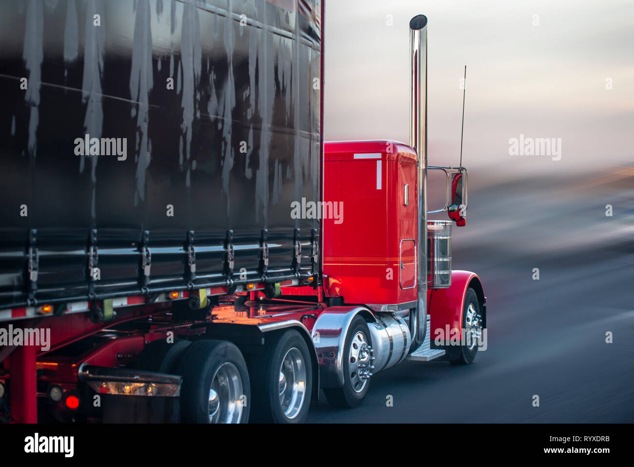 https://c8.alamy.com/comp/RYXDRB/big-rig-red-american-classic-bonnet-long-hauler-semi-truck-with-rubberized-fabric-covered-black-semi-trailer-moving-on-wet-raining-road-with-rain-dust-RYXDRB.jpg