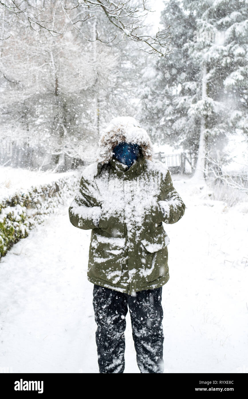 Man in a winter coat covered in snow. Scotland Stock Photo
