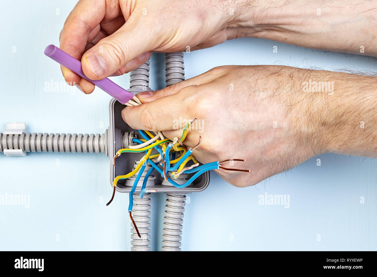 Electrician is using heat shrink tubing for joining ends of wire together for good contact. Stock Photo