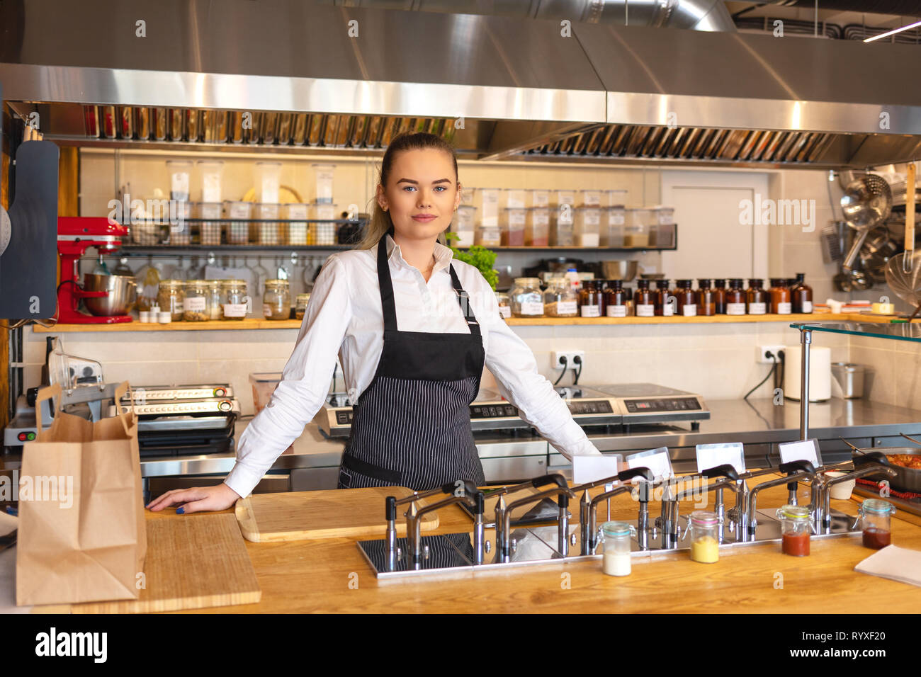 Successful owner standing behind counter in small eatery restaurant Stock Photo