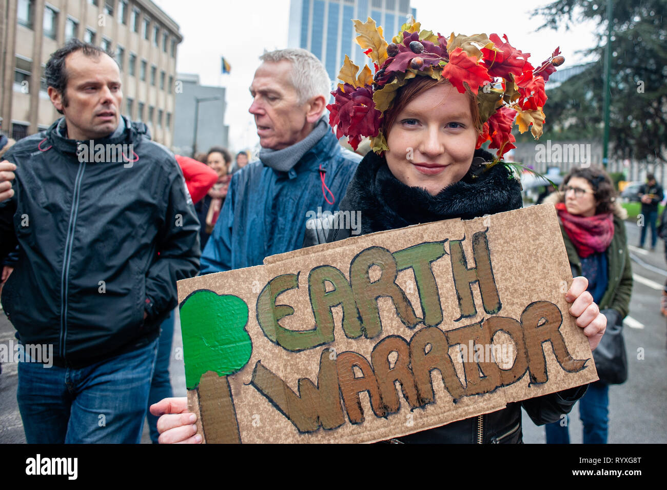 A woman is seen holding a placard that says Earth warrior during the Global climate strike for future rally. This Friday, tens of thousands of kids in more of 60 countries went on strike to demand climate change action. The school strike movement was inspired by Swedish teenager Greta Thunberg, who has been striking from school every Friday since last August to stand outside the Swedish parliament building and demand that her home country adheres to the Paris agreement on climate change. In Brussels, not just students, but teachers, scientists, and several syndicates took the streets of the Be Stock Photo