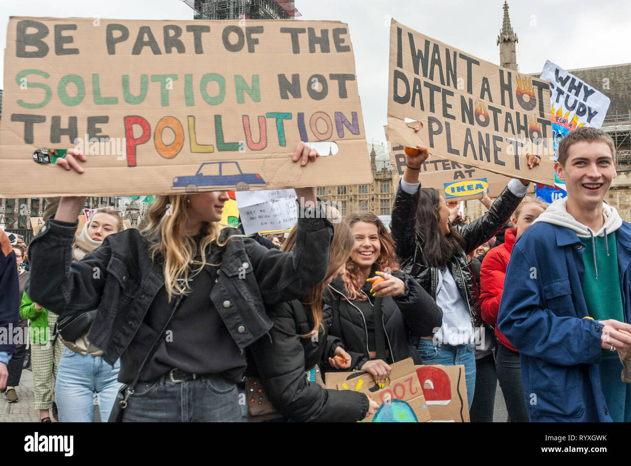 London, UK. 15th March, 2019. School students campaigning against climate change protest outside Parliament. Credit: Maggie sully/Alamy Live News. School children on strike to protest at climate change gathering outside Parliament, London. The students, boys and girls, smile and shout and carry colourful homemade banners 'Be part of the solution not the pollution', and 'I want a hot date not a hot planet'. Part of the worldwide 'FridaysforFuture' protest. Stock Photo