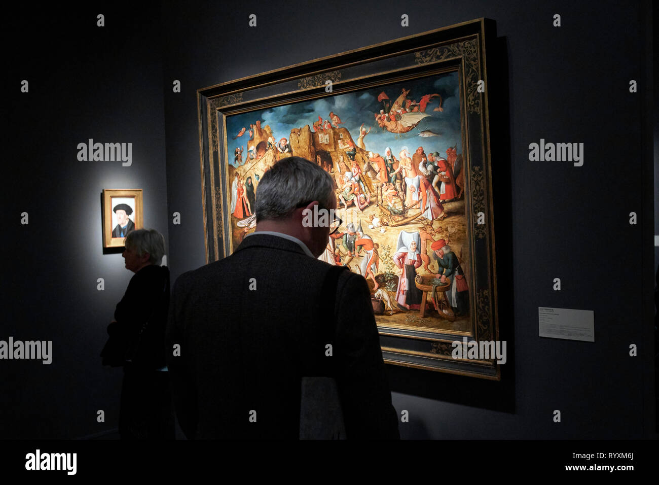 A visitor observes the paintings exhibited in one of the galleries participating in TEFAF. TEFAF (The European Fine Art Fair), one of the most famous art, antiques and design fairs in the world, is held once again this year. Every year, Maastricht hosts an event that brings together 275 galleries some twenty countries, about 30.000 exhibited art objects and has more than 75,000 attendees each year. Stock Photo