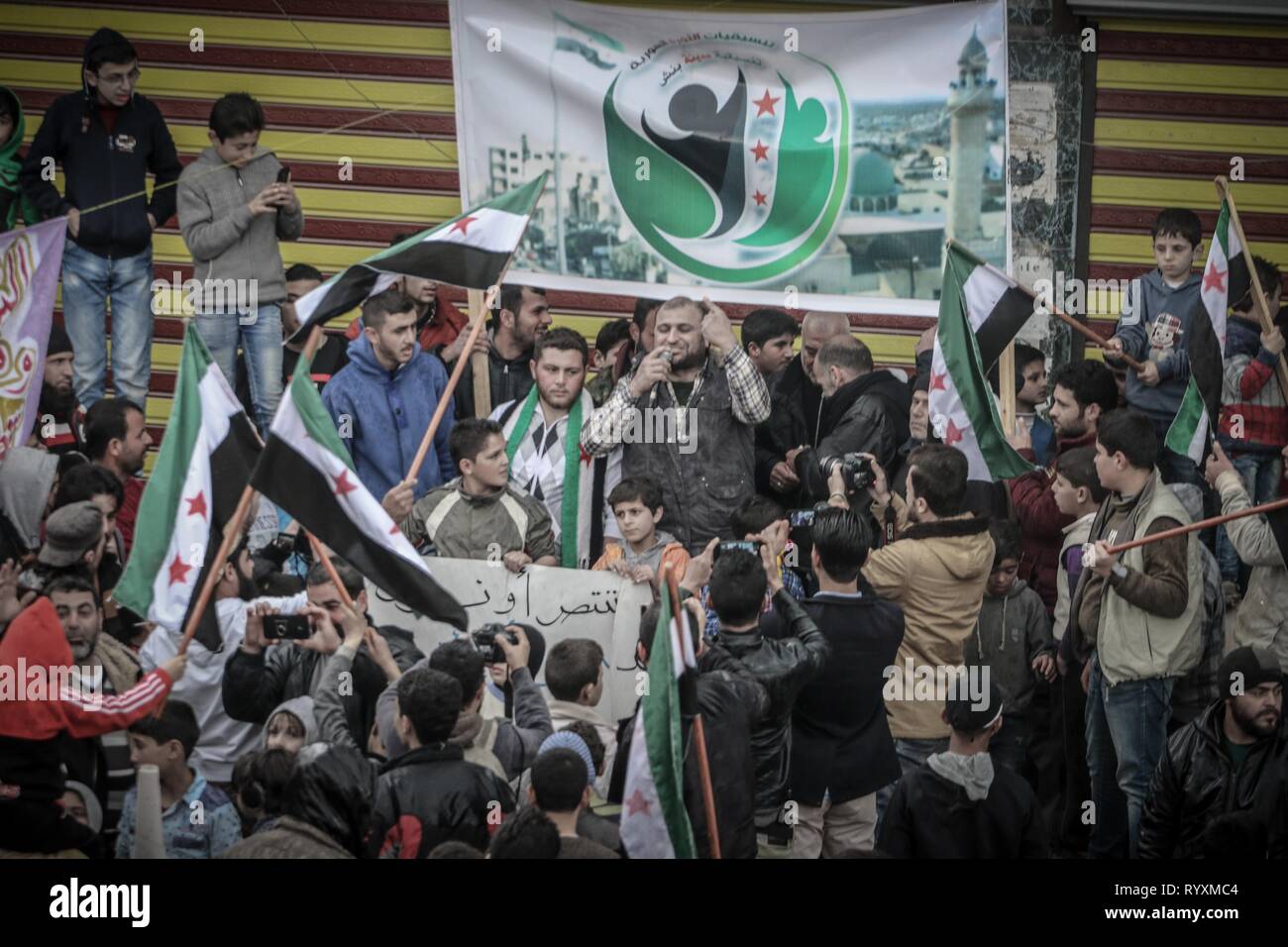 Benesh, Idleb, Syria. 15th Mar, 2019. Syrians are seen holding opposition flags during the celebration.Syrians in the town of Bensh, which lies east of Idlib and controlled by the opposition, celebrated the eighth anniversary of the uprising against the rule of President Bashar al-Assad. Credit: Mohamad Saeed/SOPA Images/ZUMA Wire/Alamy Live News Stock Photo