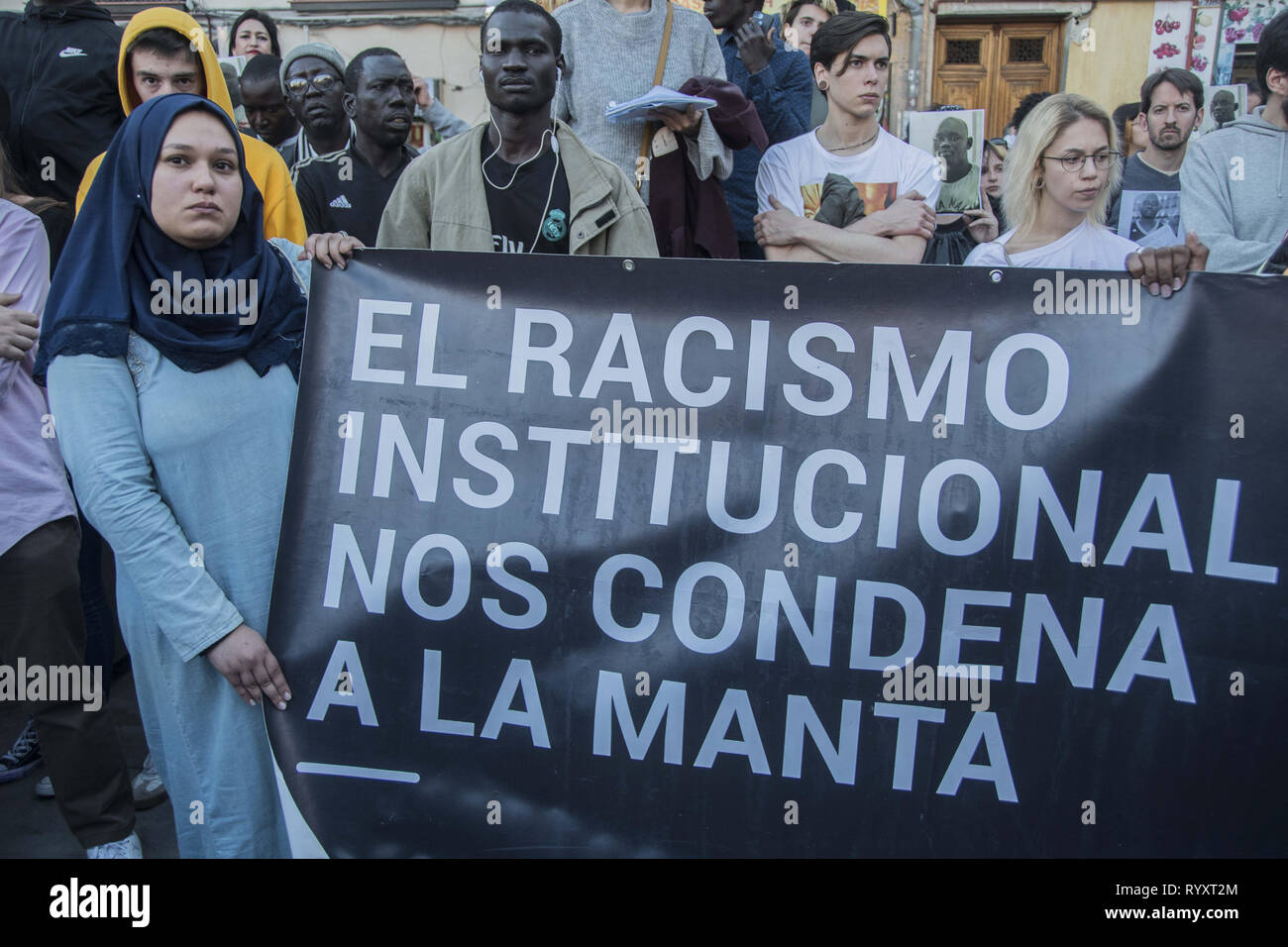 Madrid, Madrid, Spain. 15th Mar, 2019. A woman with a placard Â¨Institutional racism condemns us and kills usÂ¨ in the Nelson Mandela square. March to commemorate one year of the death of senegalese vendor Mame Mbaye in calle del Oso in the neighbourhood of Lavapies. one year ago there was a clashes between police and immigrants after Mame Mbaye, a Senegalese street vendor, died of a cardiac arrest allegedly after being chased by local police. Credit: Alberto Sibaja/SOPA Images/ZUMA Wire/Alamy Live News Stock Photo