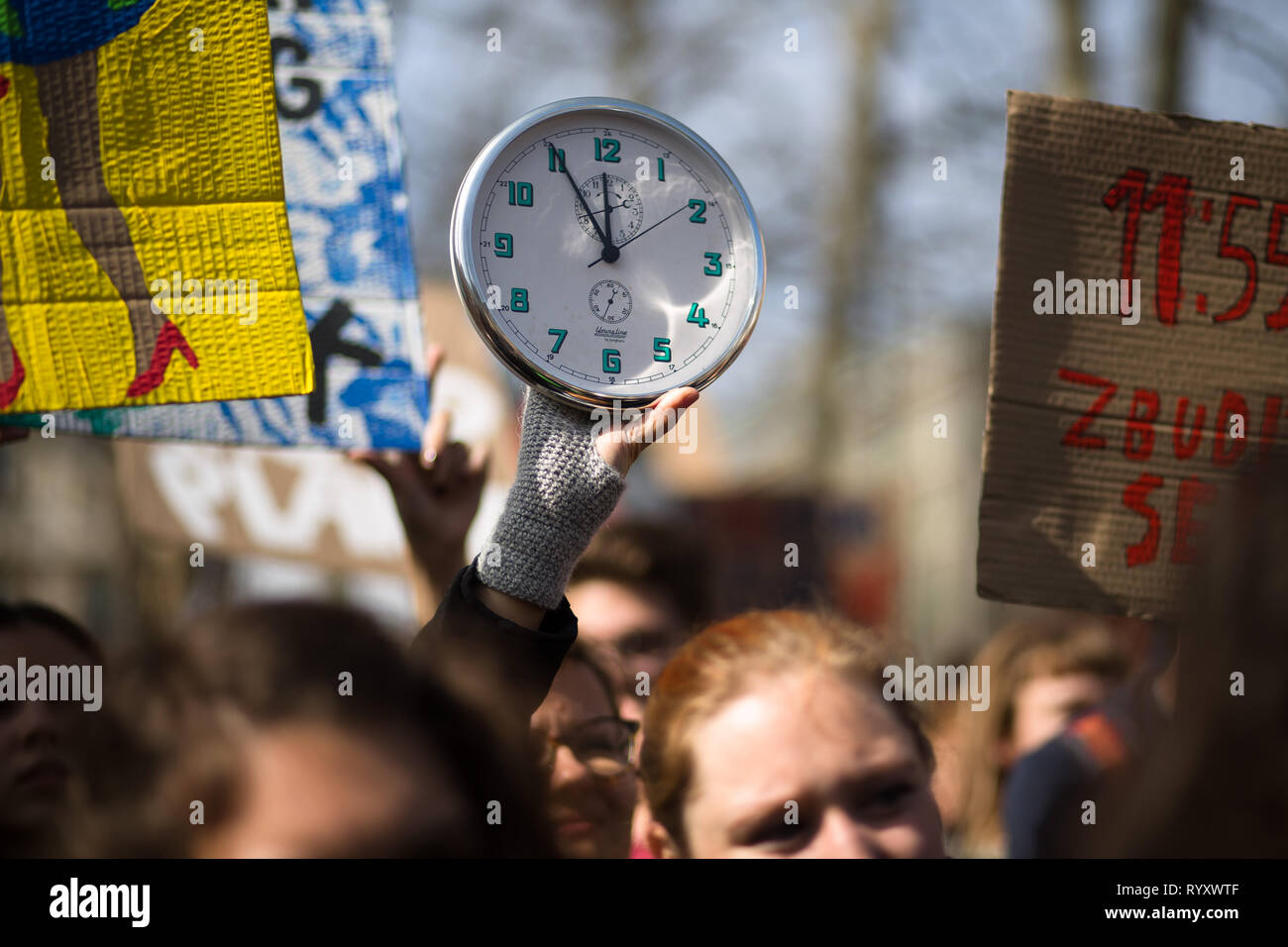 Beijing, Slovenia. 15th Mar, 2019. A protester holds up a clock that stands at 11:55, a symbolic high time to act, during a Youth Climate Strike in Ljubljana, Slovenia, on March 15, 2019. Around 5,000 students protested against inaction on climate change in Ljubljana, as part of a global Youth Climate Strike on Friday. Credit: Luka Dakskobler/Xinhua/Alamy Live News Stock Photo