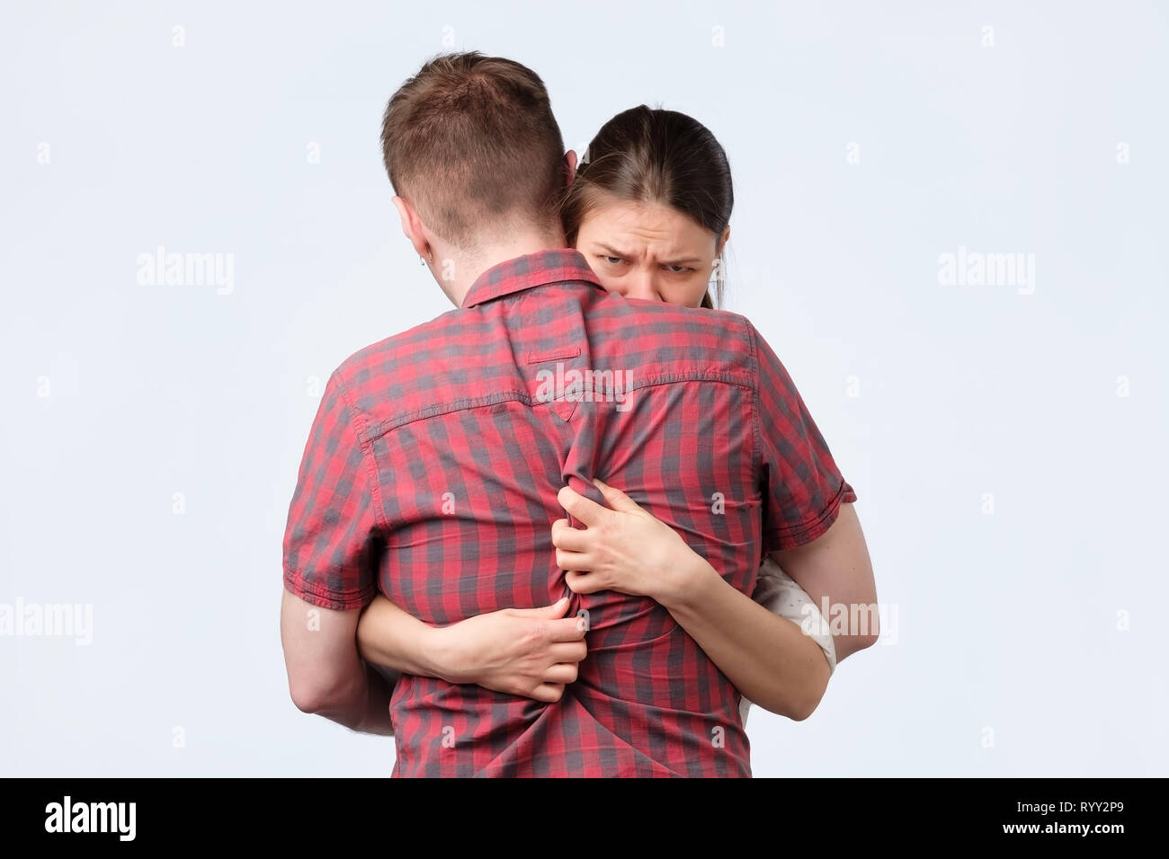 Girl is hugging her husband as is afraid to lose him. Stock Photo