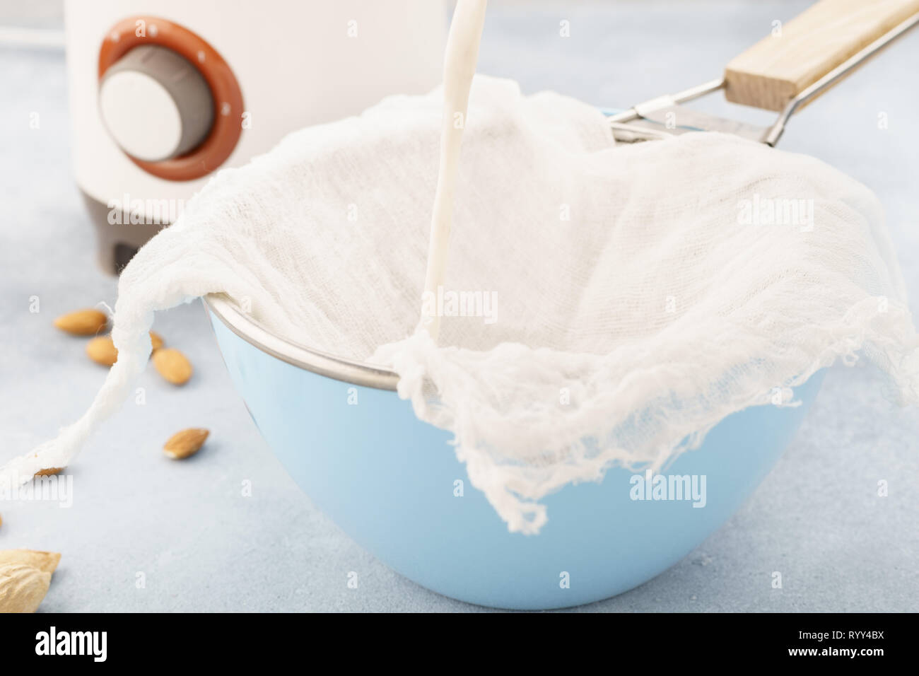 Homemade nut milk making process. Pouring milk into cloth. Step by step recipe. Stock Photo