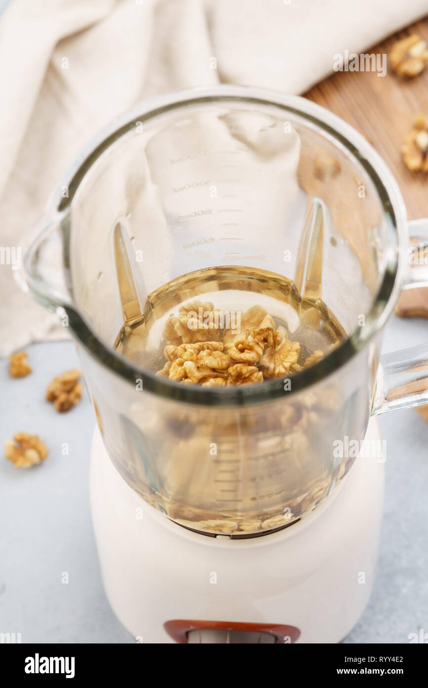 Blender and walnuts soaked in water. Making healthy vegan milk Stock Photo Alamy