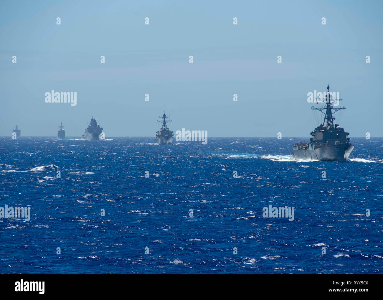 190314-N-WK982-2013 PHILIPPINE SEA (March 14, 2019) The Arleigh Burke-class guided-missile destroyer USS McCampbell (DDG 85), the Arleigh Burke-class guided-missile destroyer USS Milius (DDG 69), the amphibious transport dock ship USS Green Bay (LPD 20), the Ticonderoga-class guided-missile cruiser USS Chancellorsville (CG 62), and the amphibious dock landing ship USS Ashland (LSD 48) maneuver while operating in the Philippine Sea. U.S. Navy warships train together to increase the tactical proficiency, lethality, and interoperability of participating units in an Era of Great Power Competition. Stock Photo