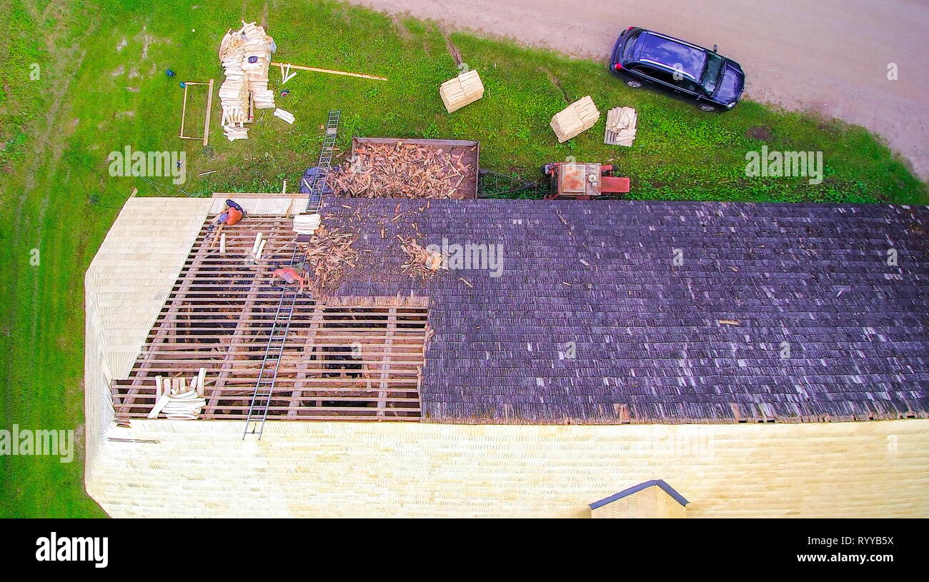Removing of old shingles on the roof with a roofer installing new