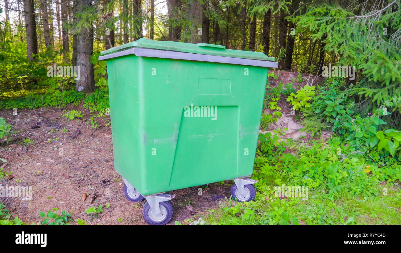The big green trashbin with the trees on the back where garbage are ...