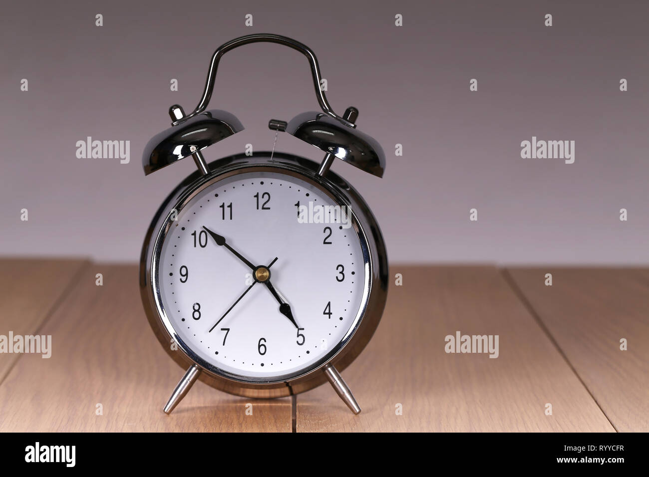 The old alarm clock on a light background Stock Photo - Alamy