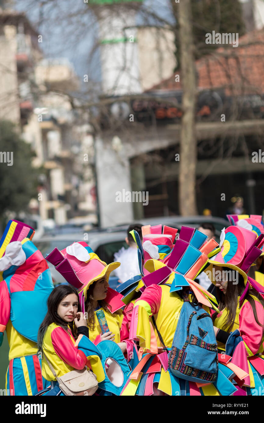 XANTHI, GREECE - MARCH 10, 2019: Masquerade participants march and have fun in colorful costumes. Small and big groups of Greek people parade annually Stock Photo