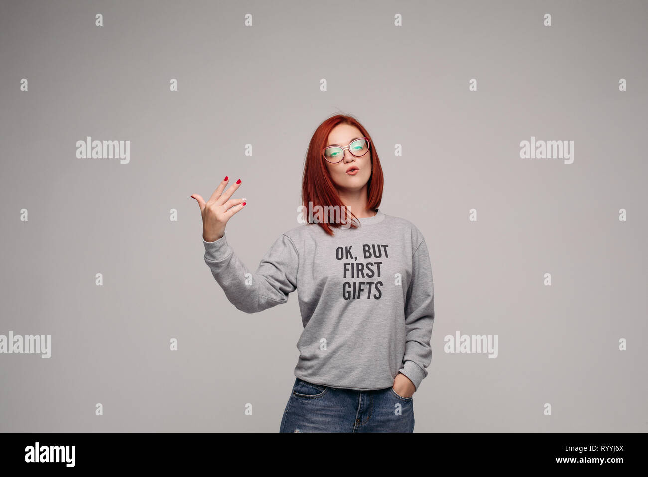 Swag and confident red haired girl in jeans and sweatshirt