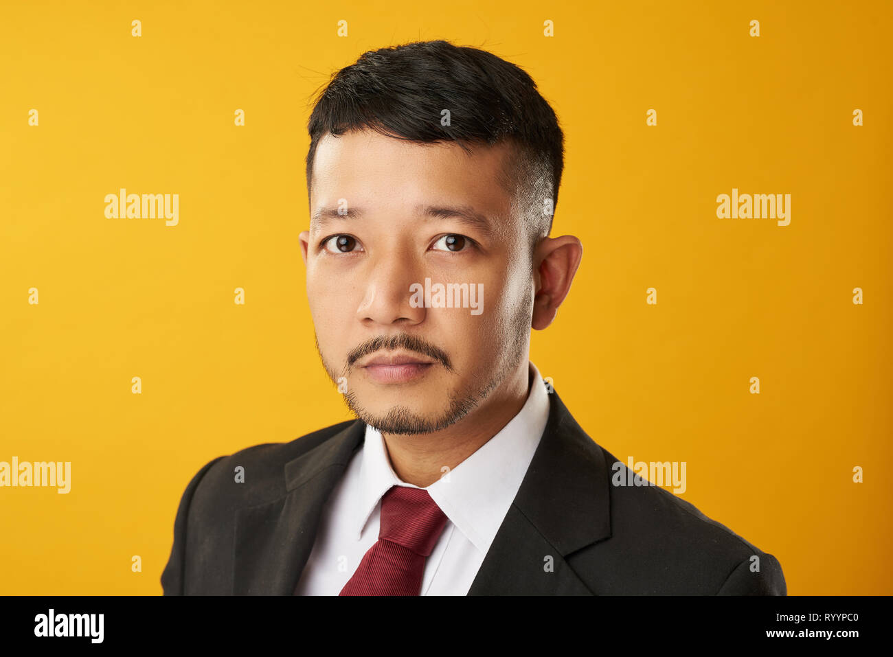 Asian office worker guy headshot on yellow color background Stock Photo