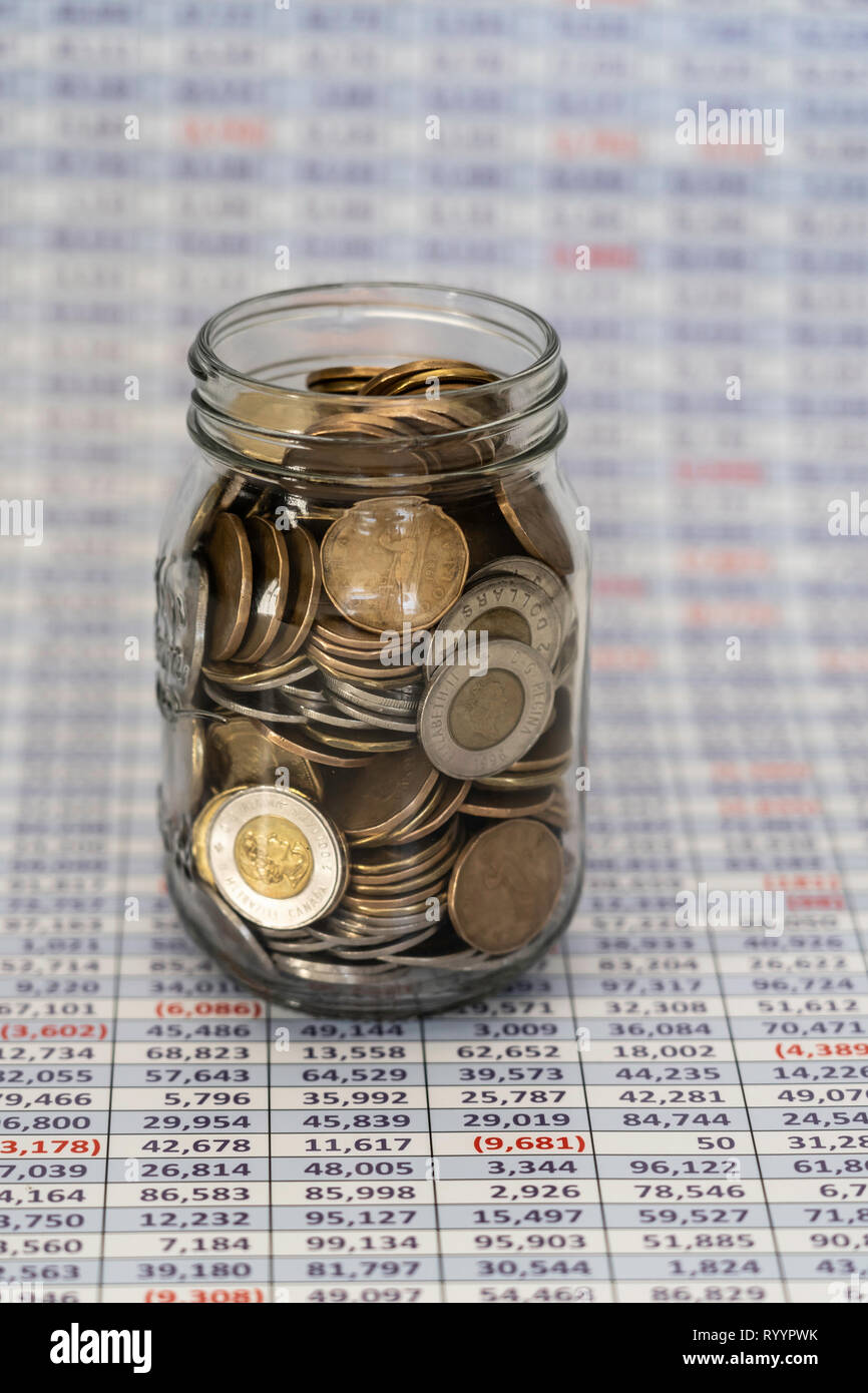 Jar full of coins with Spreadsheet in bavckground Stock Photo Alamy