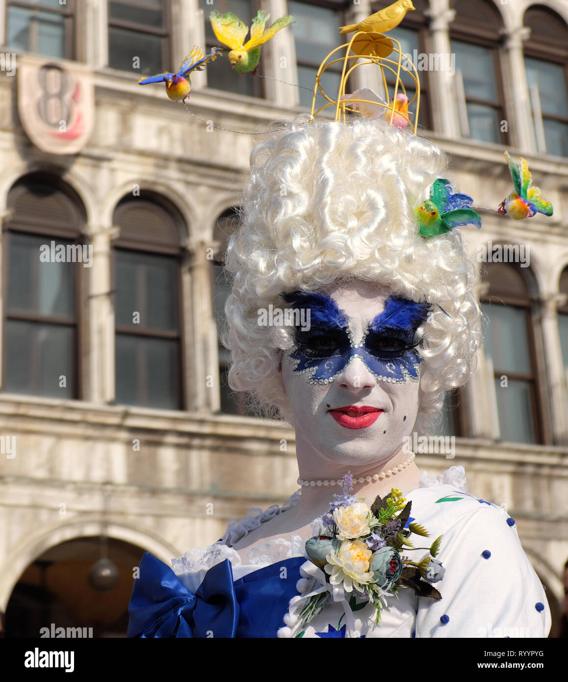 Man dressed as woman traditional mask and costume for Venice Carnival standing in Piazza San Marco, Venice, Veneto, Italy Stock Photo