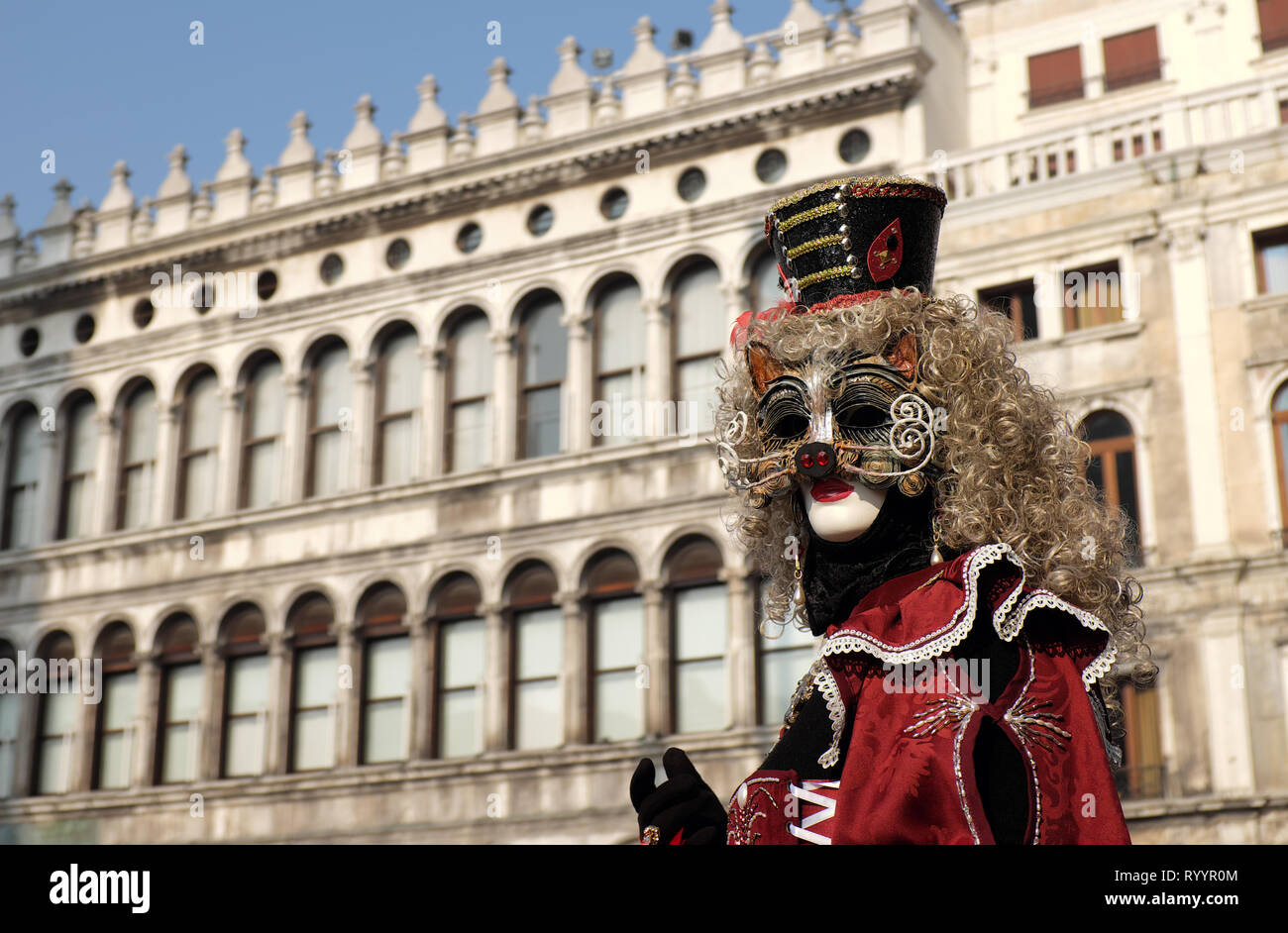 Woman dressed in traditional mask and costume for Venice Carnival standing in Piazza San Marco, Venice, Veneto, Italy Stock Photo