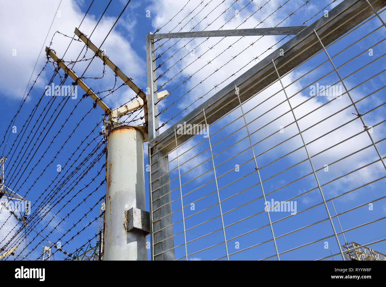 Industrial metal fence with barbed wire Stock Photo Alamy
