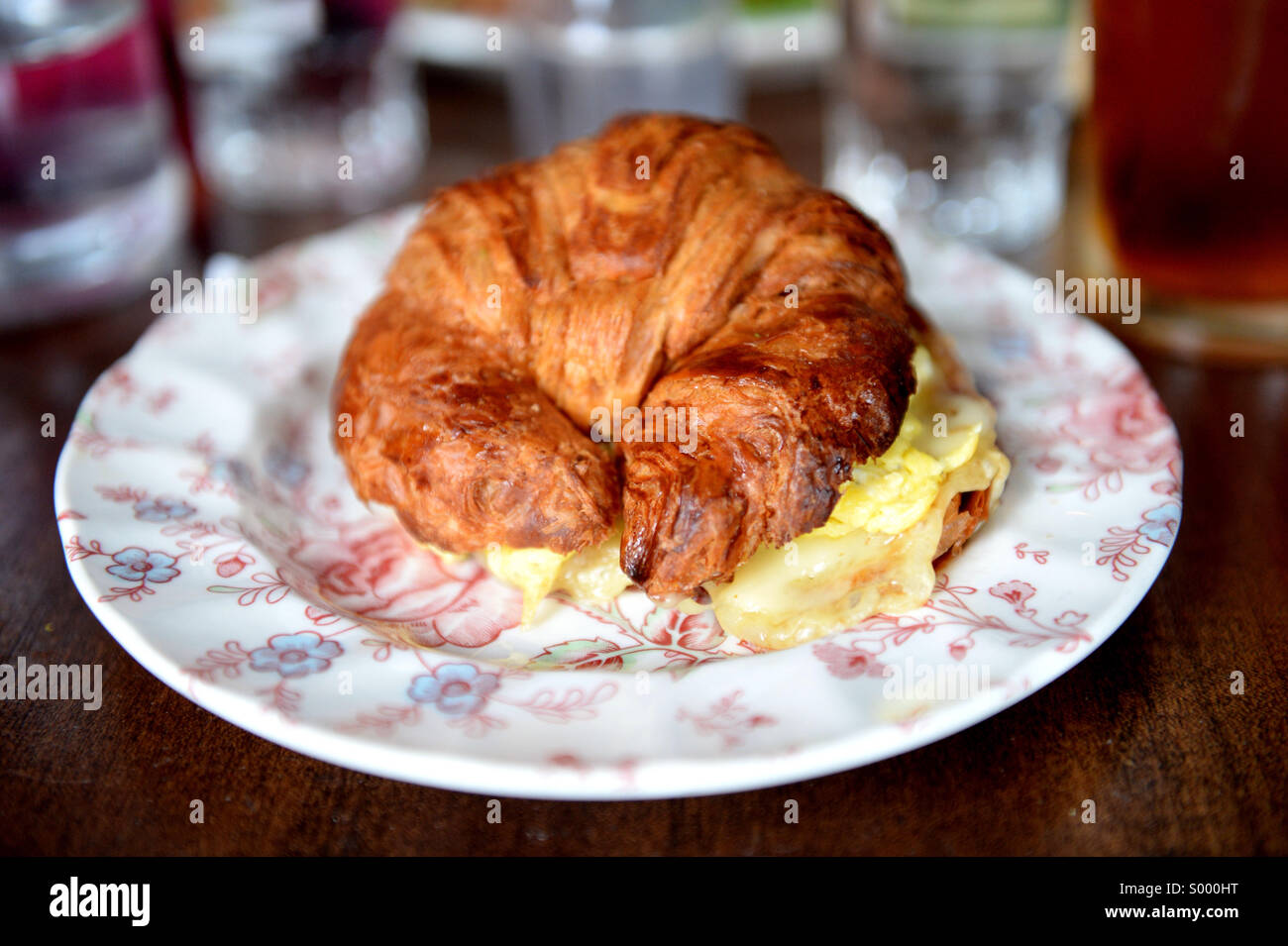 A fried egg and cheese of a croissant sandwich. Stock Photo