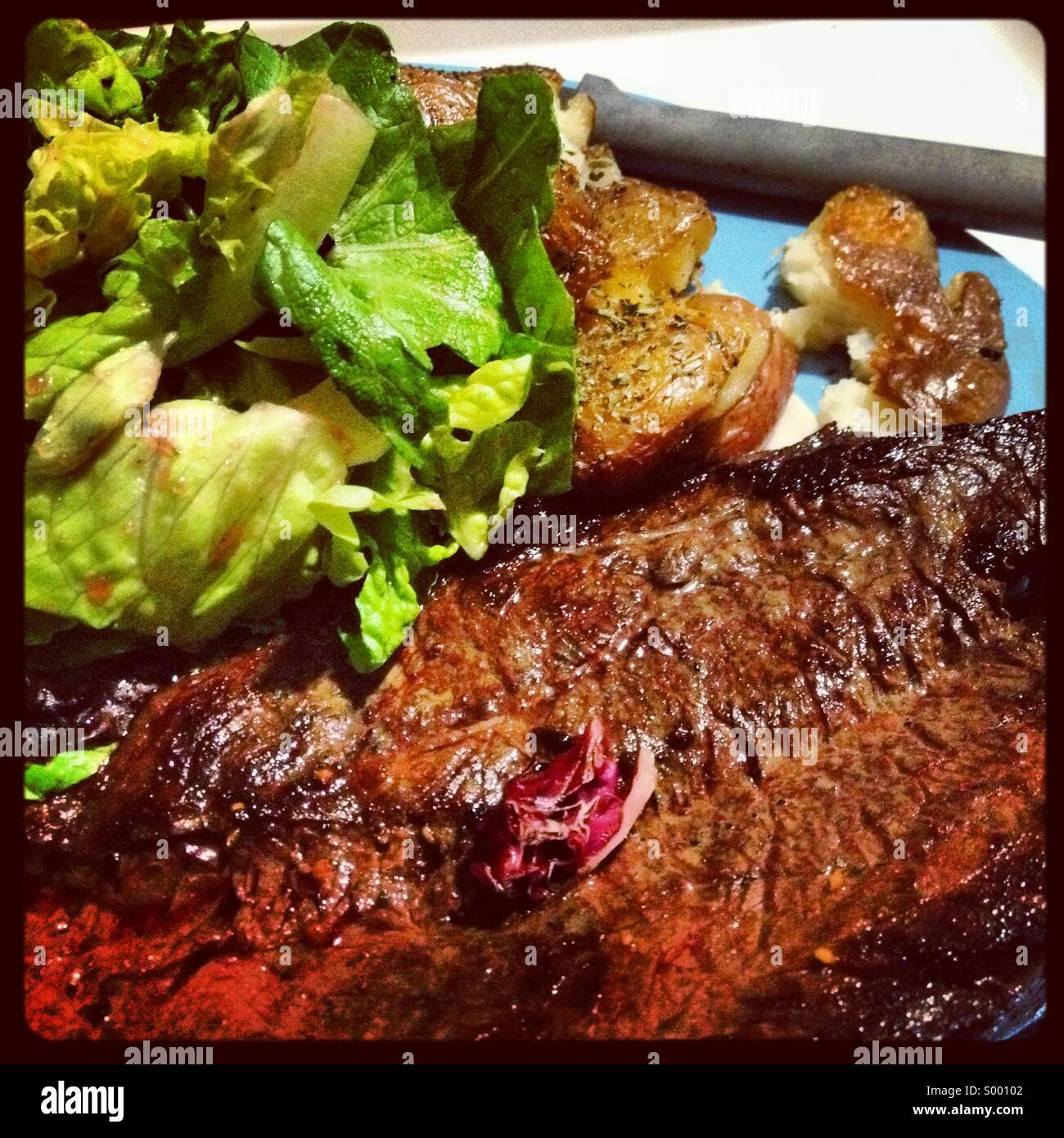 Grilled skirt steak with roasted potatoes and green salad Stock Photo