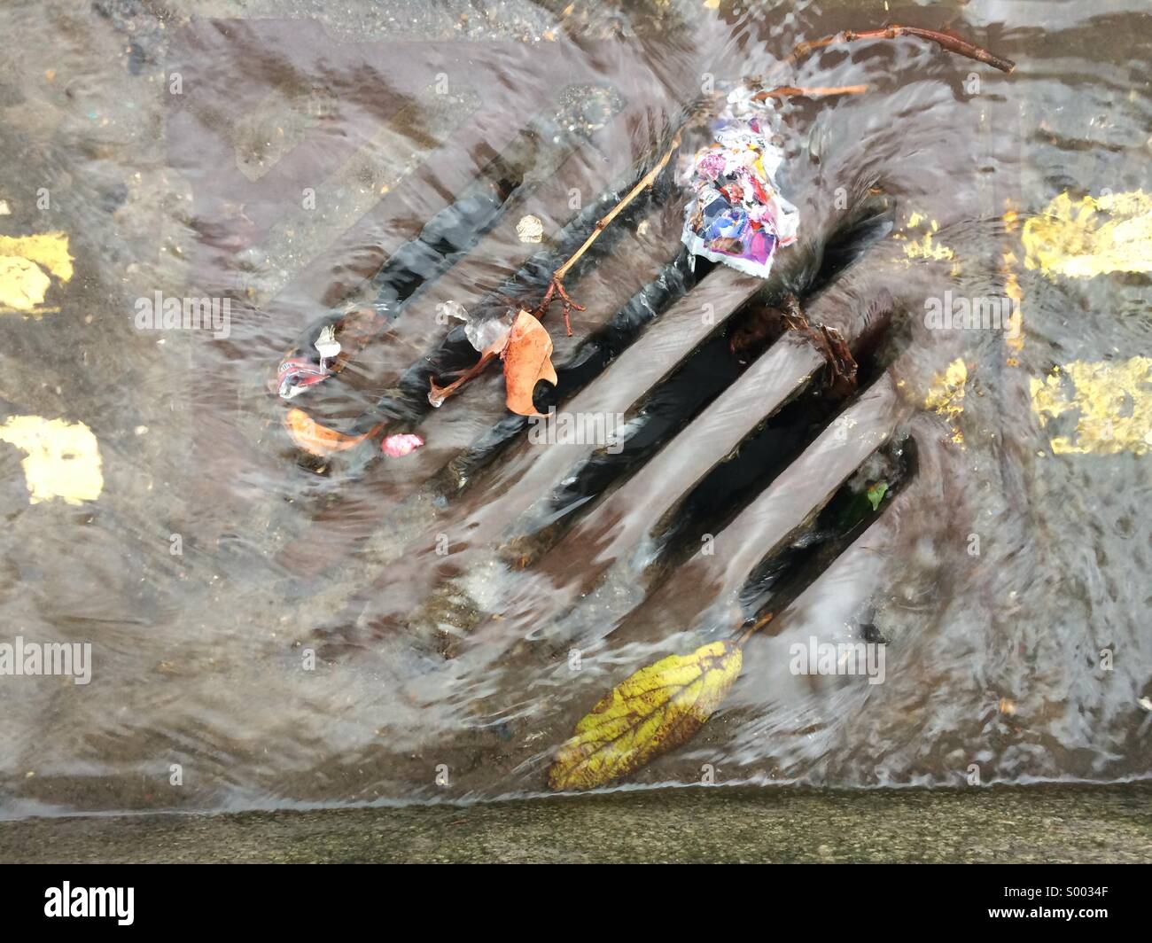Water running down the drain in a street. - Smartphone Captured Stock Image
