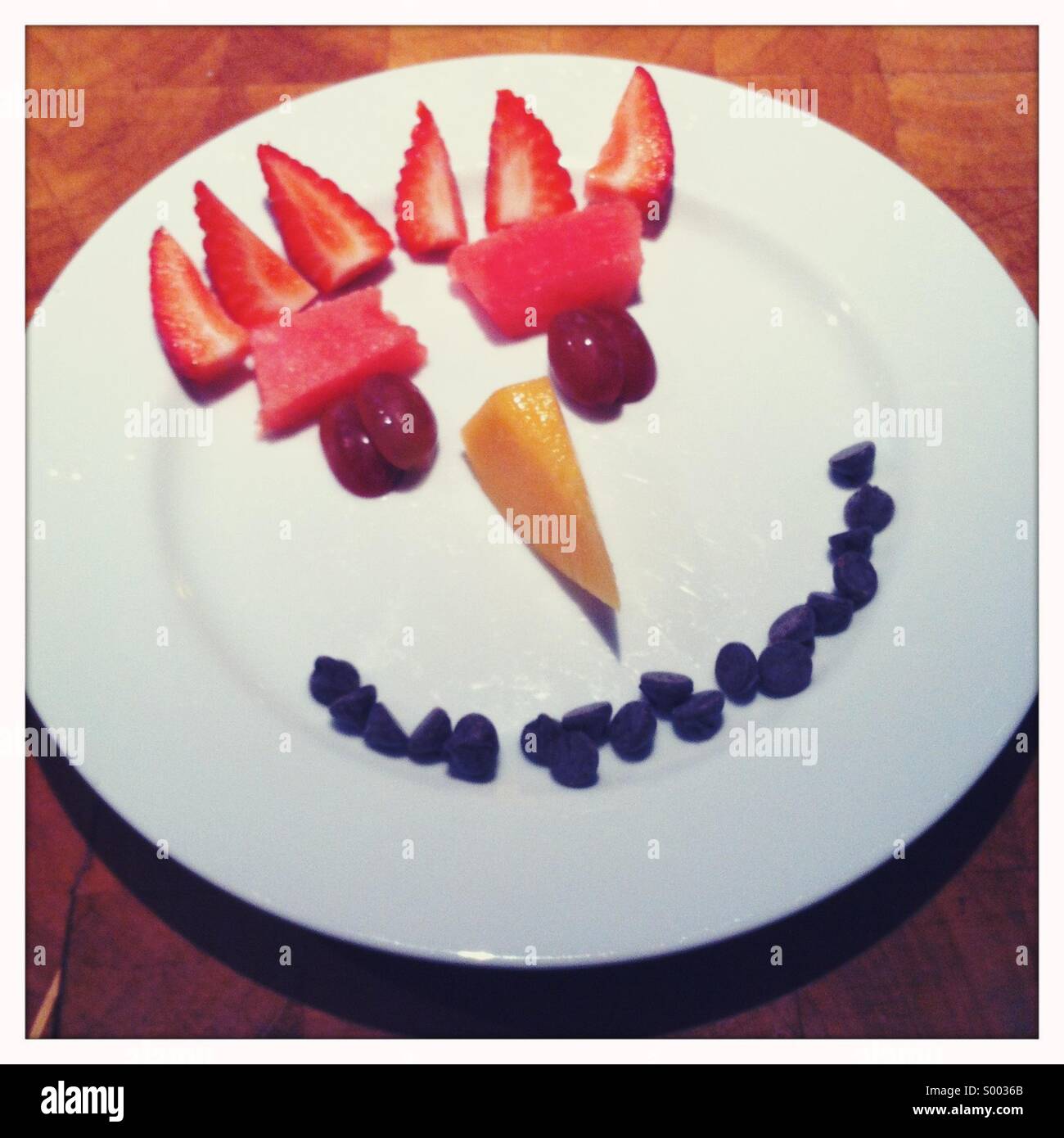 A child's plate with a face created with food Stock Photo