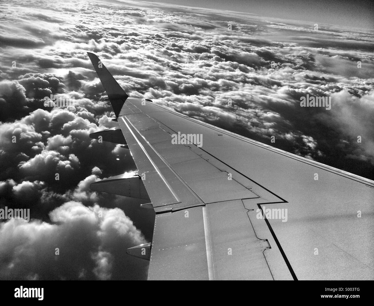 The wing of an aircraft above a cloudy sky. Stock Photo