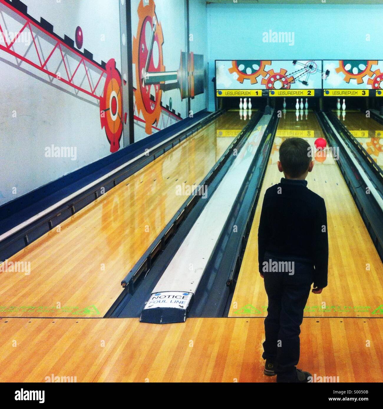 Bowling Alley With Small Boy Looking Down The Lane Stock Photo