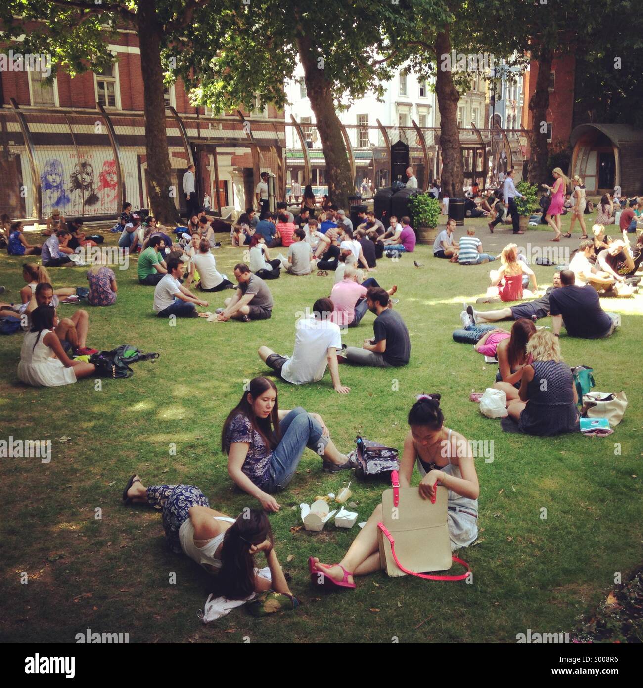 People relax in a park in Central London in the summer time. Stock Photo