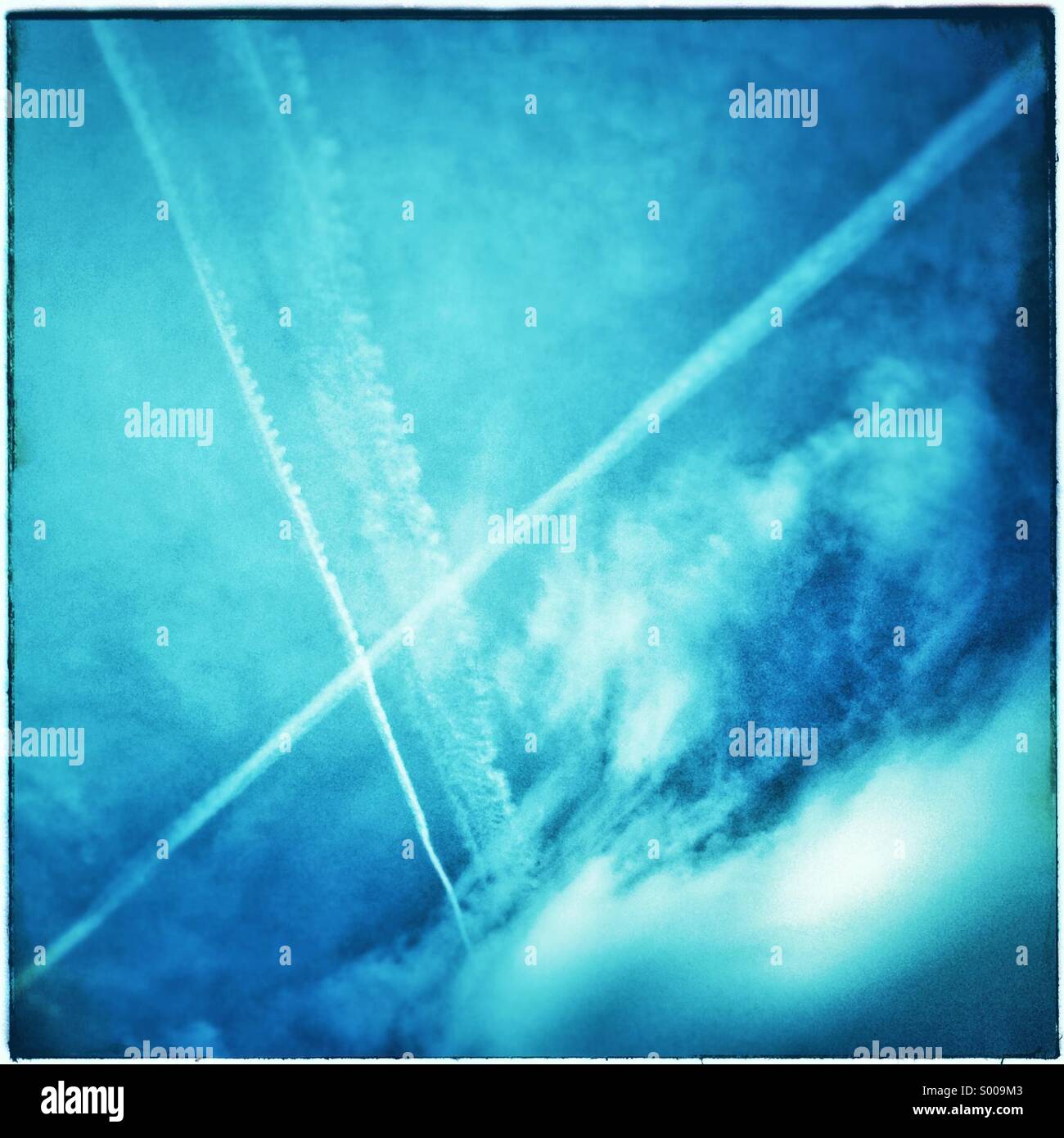 Cross sign airliner trails or condensed vapor track trails on blue sky, Barcelona, Catalonia, Spain Stock Photo