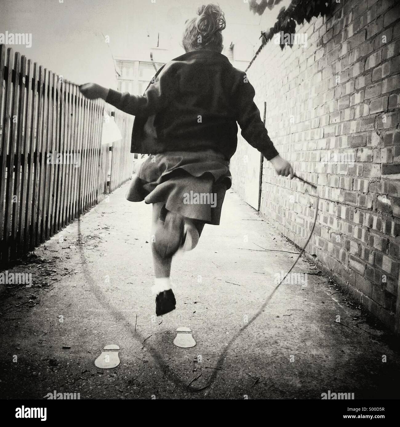 Young girl skipping against the one way system of the footprints. Rebel. Stock Photo