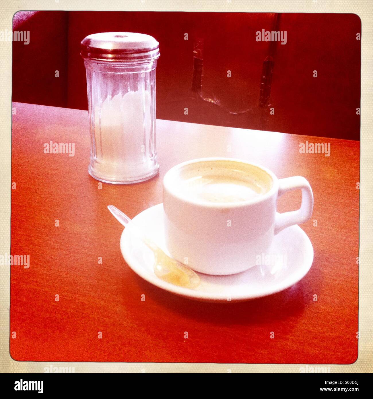 Old tea cup and saucer with retro sugar dispenser in cafe Stock Photo