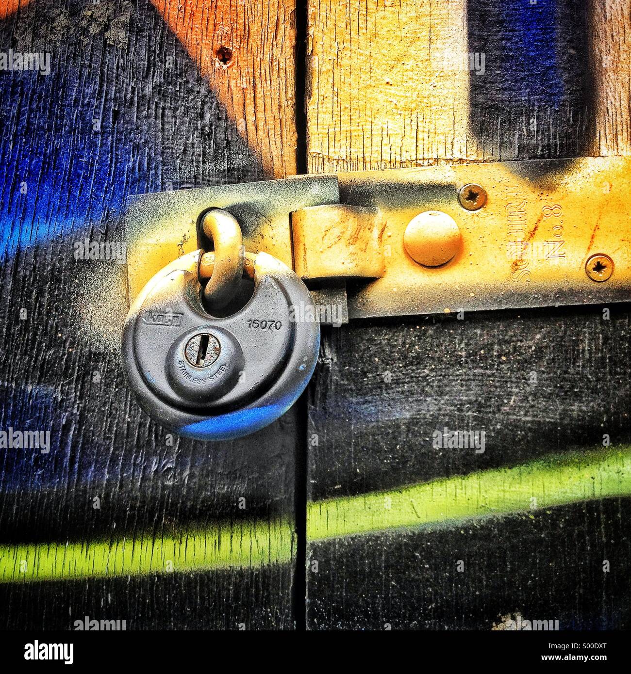 Graffiti over lock on door Stock Photo