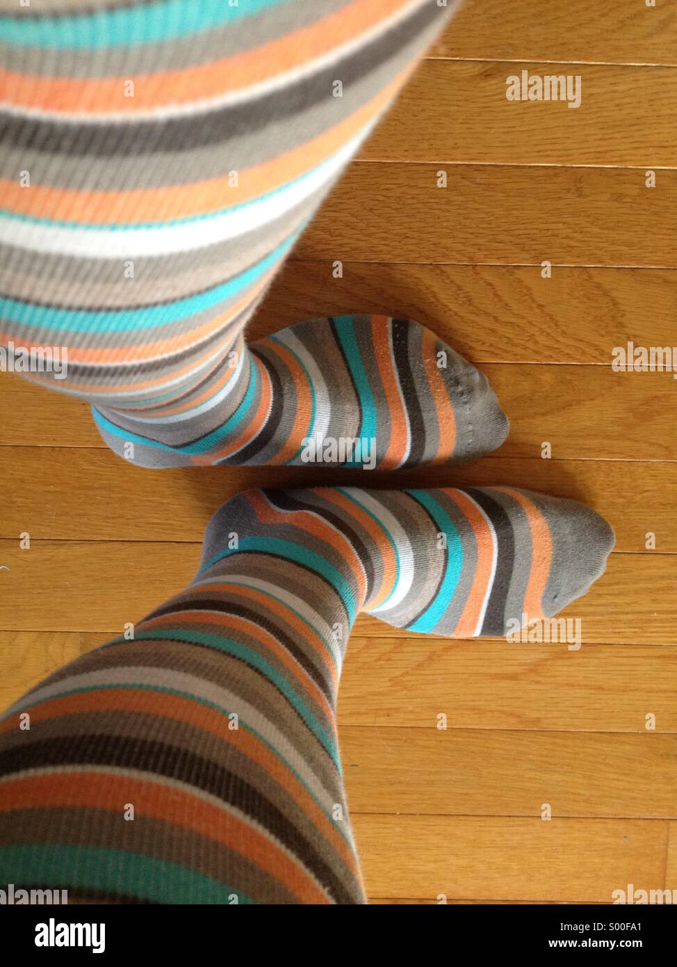 Girl's legs wearing striped knee socks; view from above Stock Photo