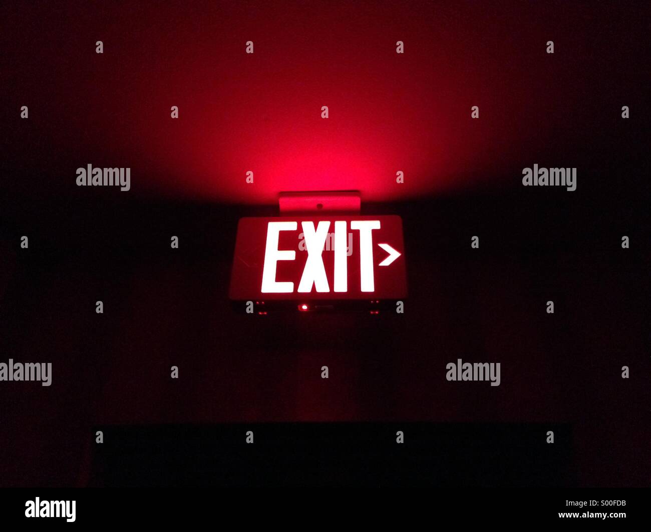 Stunning photo of an exit sign illuminating a corner, exit to the right